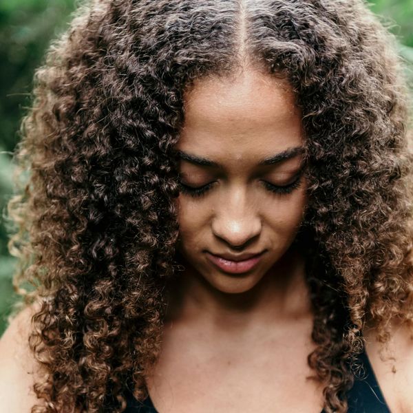 Person meditating in a serene natural environment.